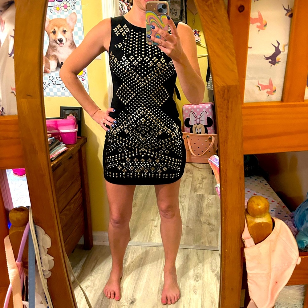 Dress gold exposed zipper up middle of the back. Back of dress is plain black.